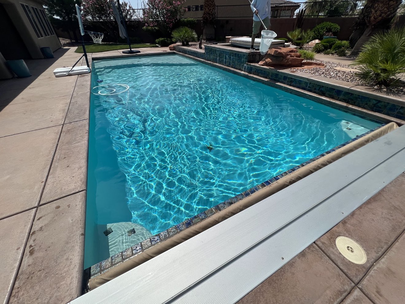 Rectangular pool with an automatic cover and clear turquoise water